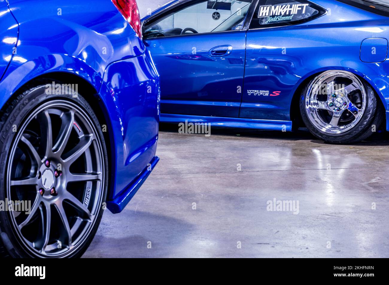 A closeup of blue 2003 Acura RSX Type S with an open hood at Hot Import