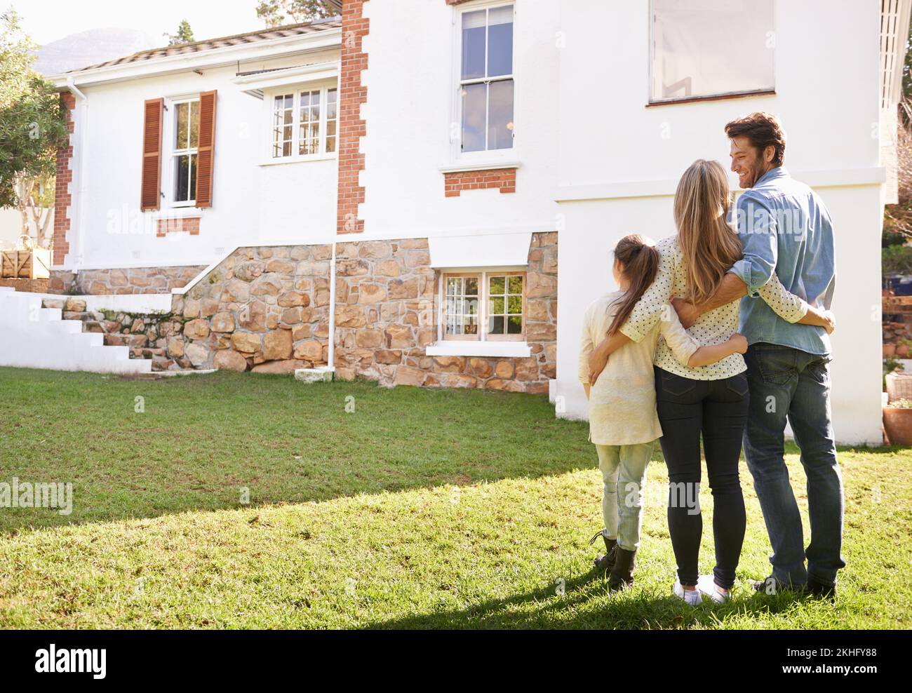 The place we call home. A family standing outdoors admiring their new home. Stock Photo