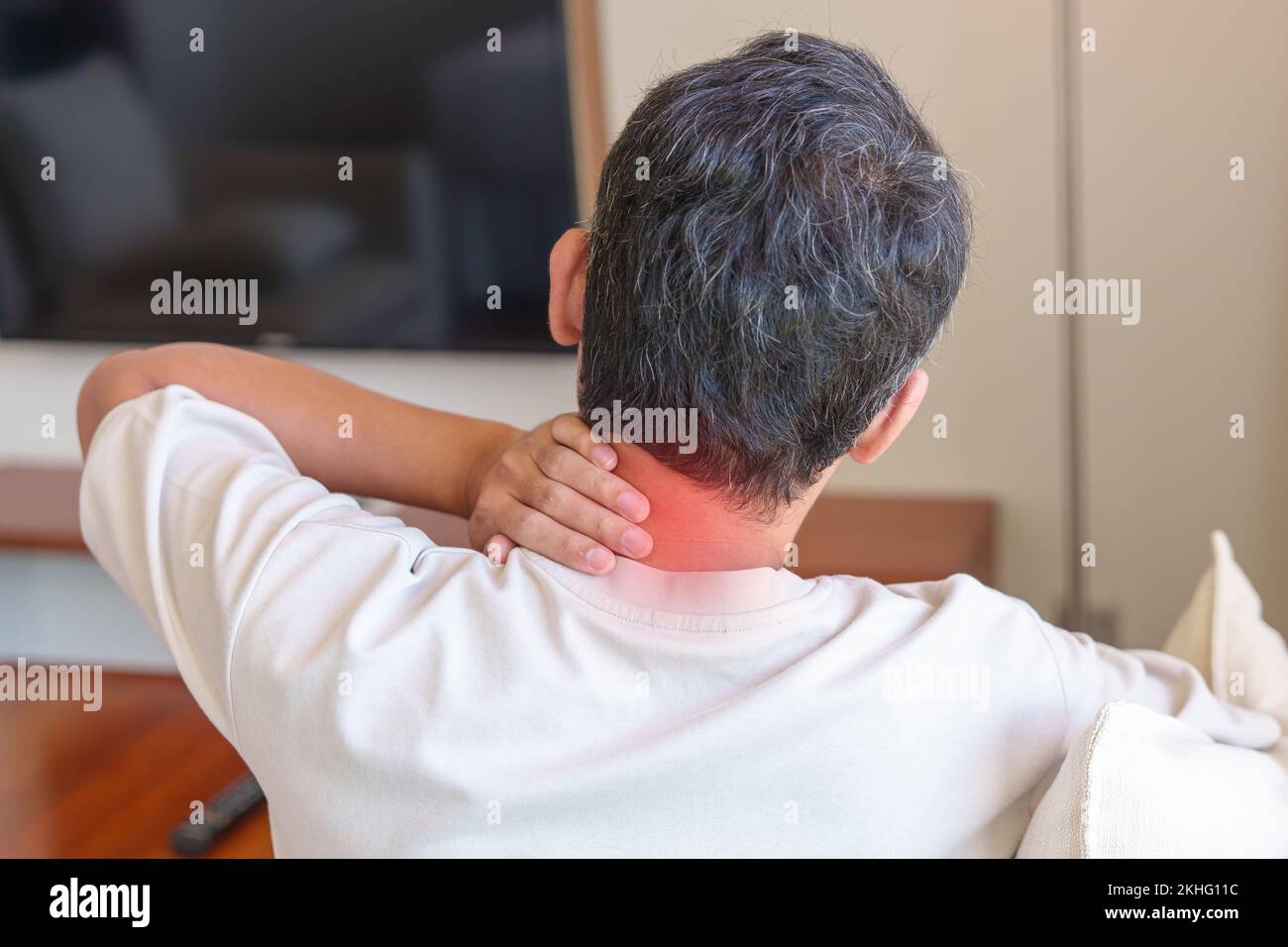 man having Neck and Shoulder pain during sitting on sofa. due to