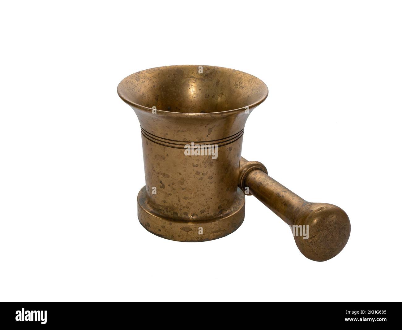 Old brass mortar and pestle lying next to it, isolated. Equipment for grinding and blending different ingredients. Concept of alchemy, herbalism, cook Stock Photo