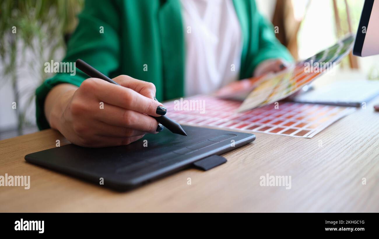 Interior designer working with fan of colourful samples and using grapgic tablet Stock Photo