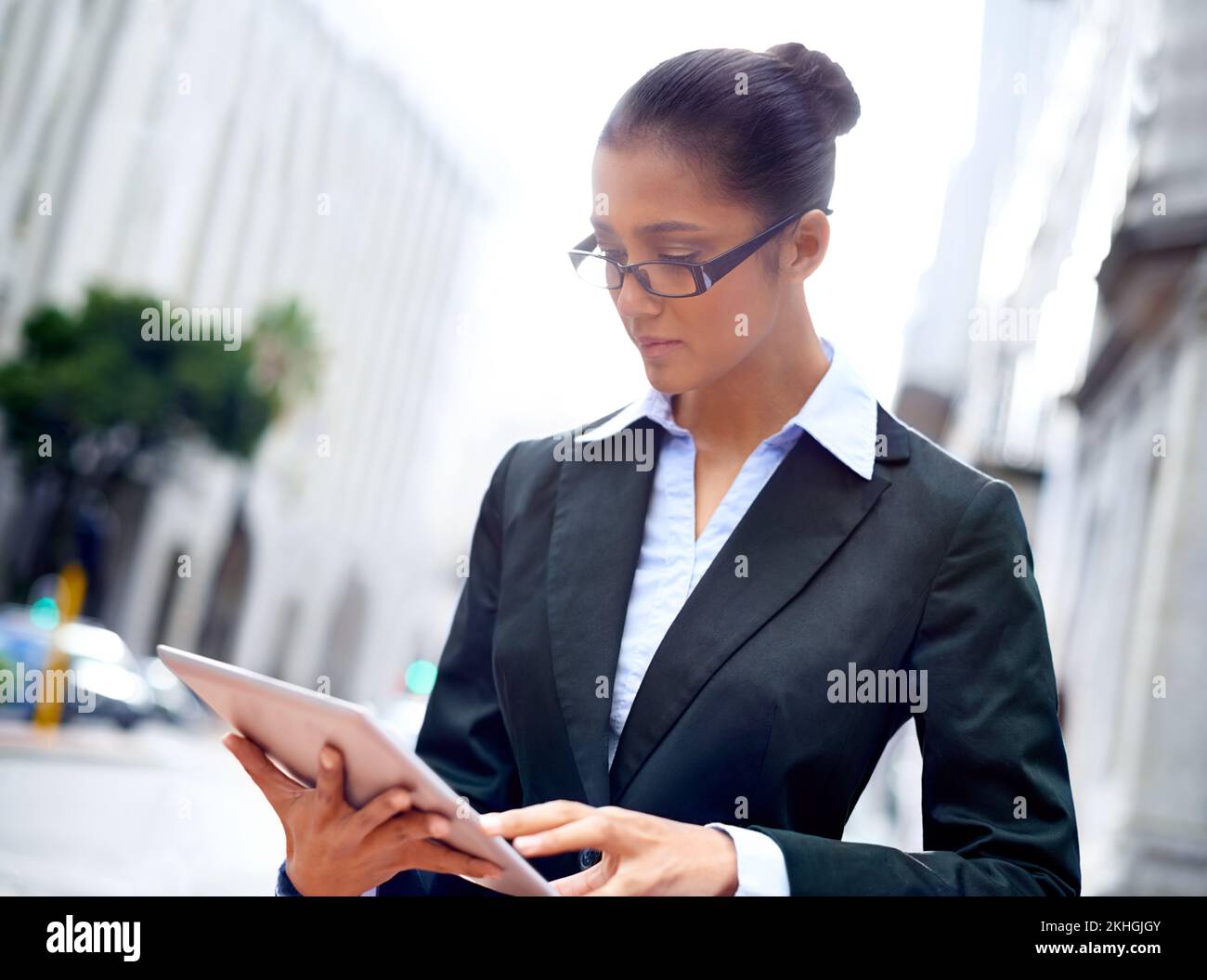 Doing business on the go. A young businesswoman using her digital tablet in the city. Stock Photo