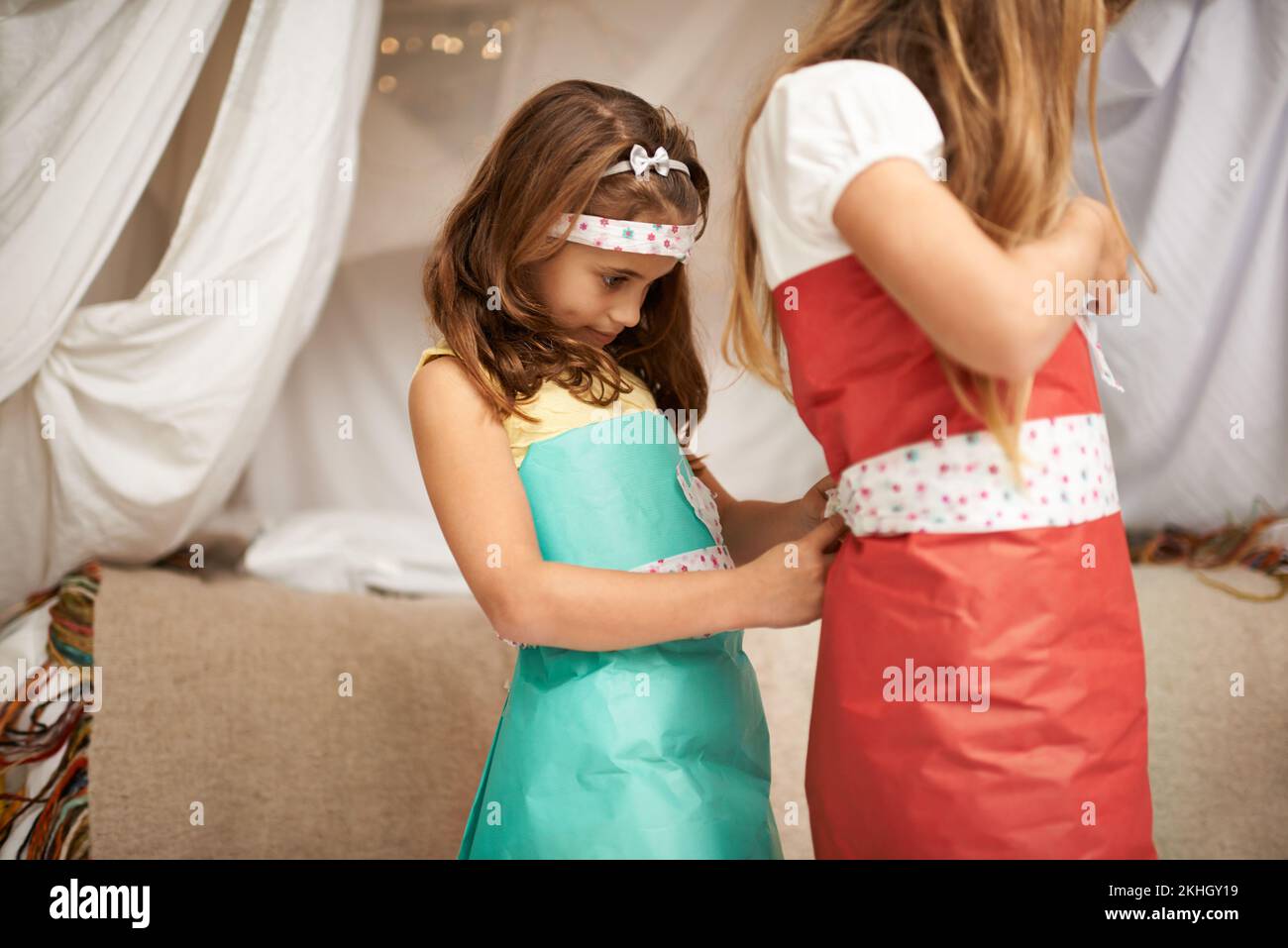 Playing the seamstress. two young sisters playing indoors. Stock Photo