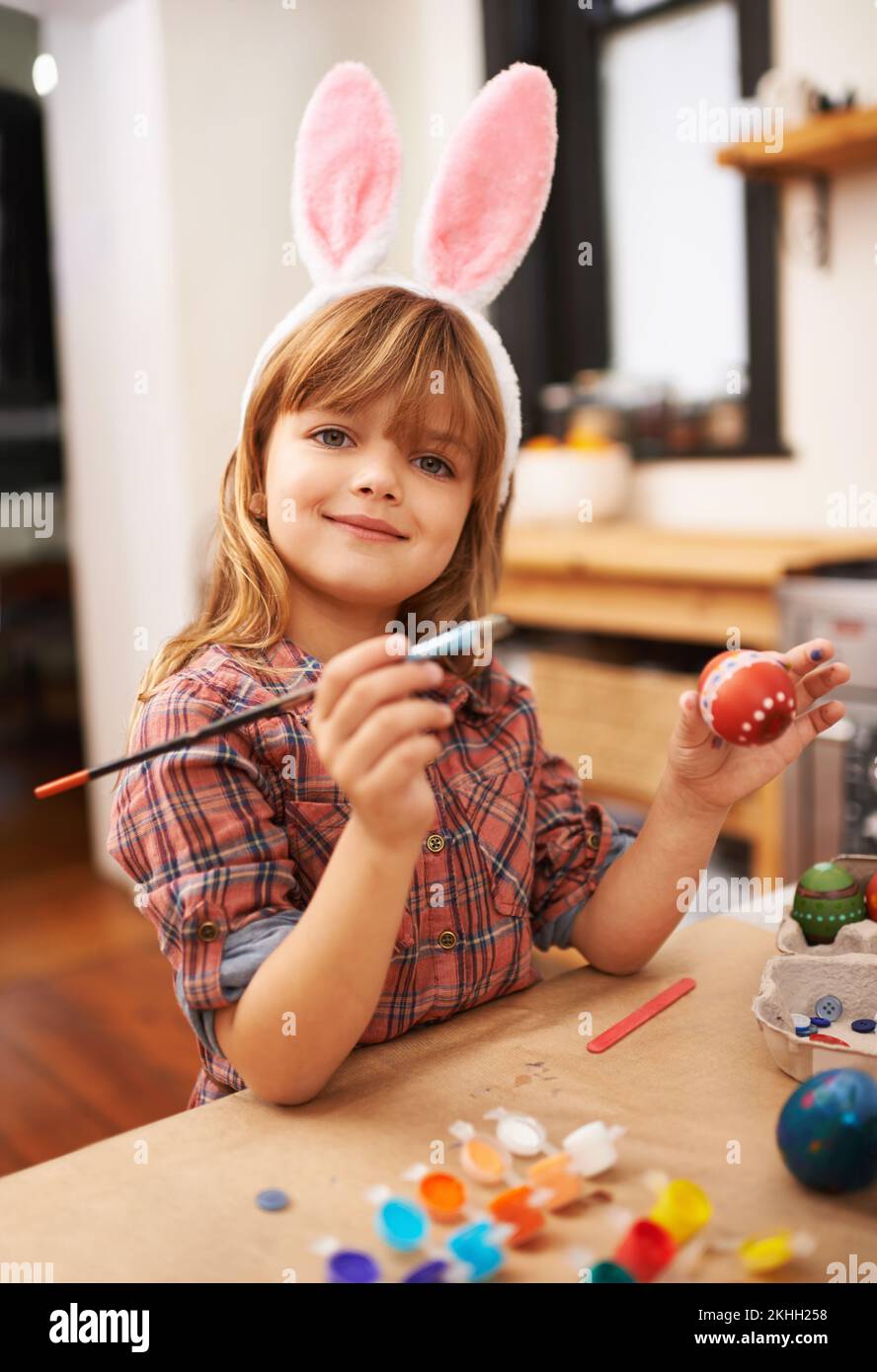 Easter bunny artwork. a little girl wearing bunny ears while painting