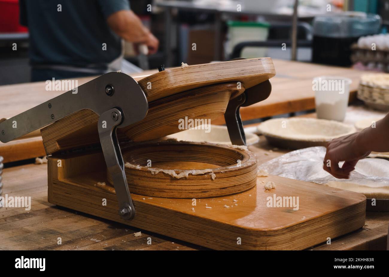 A wooden, hand-controlled pie crust press in a small, professional bakery Stock Photo