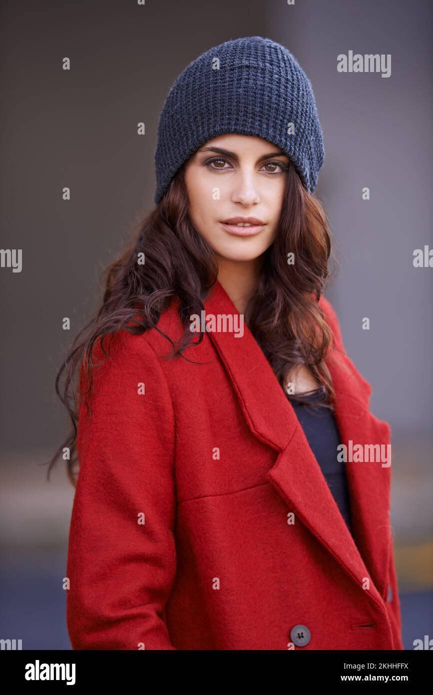 Staying with it in winter. Cropped portrait of a beautiful young woman wearing a red winter coat and a beanie. Stock Photo