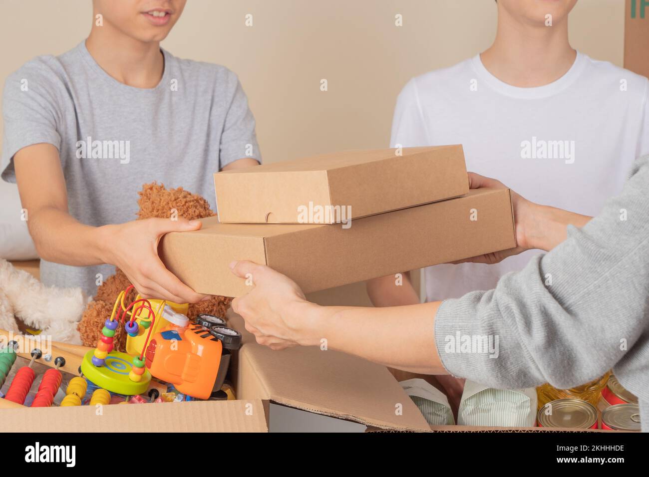 Young volunteers collect donations for charity indoors. Donation boxes
