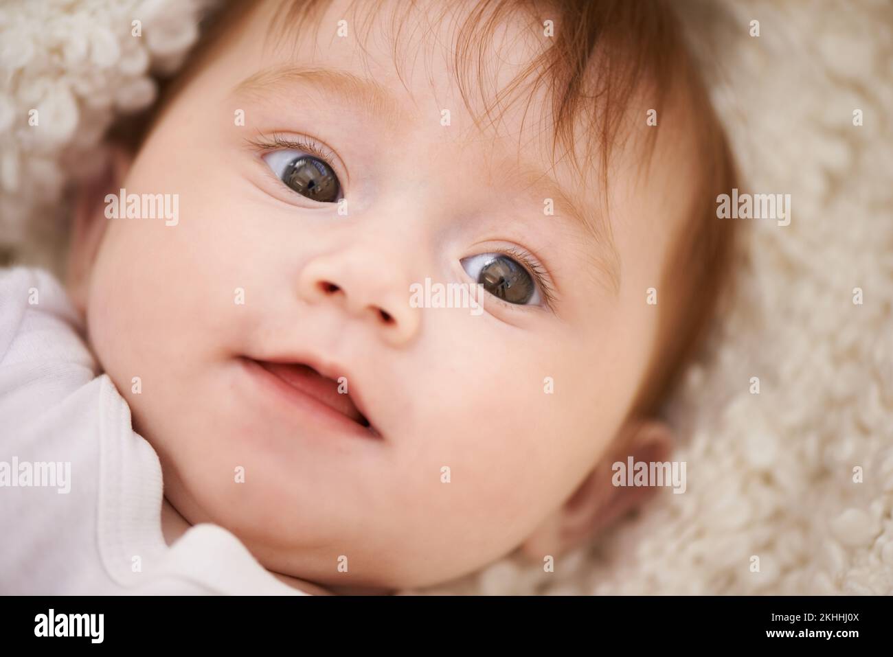 Eyes full of wonder. an adorable baby girl with red hair. Stock Photo