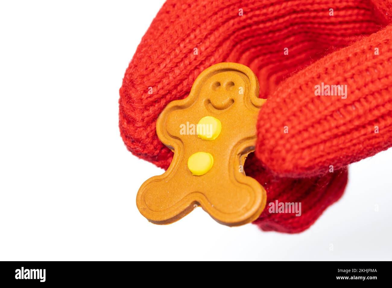 Close-up of Santa Claus holding a small gingerbread man figure in his hand on a white background Stock Photo