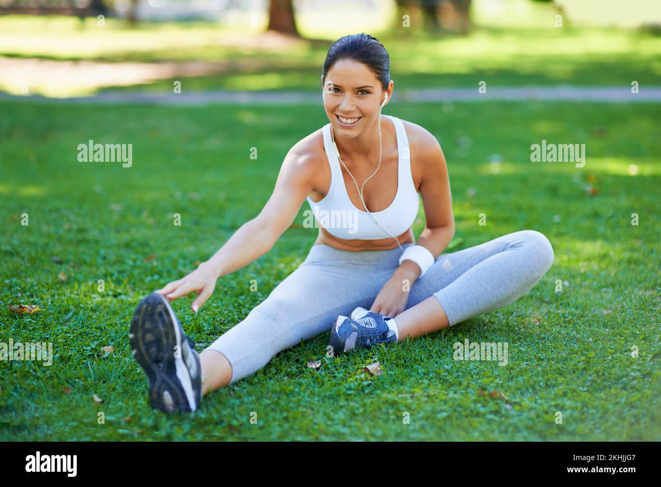 Getting limbered up for her run. a beautiful young woman stretching in the park. Stock Photo