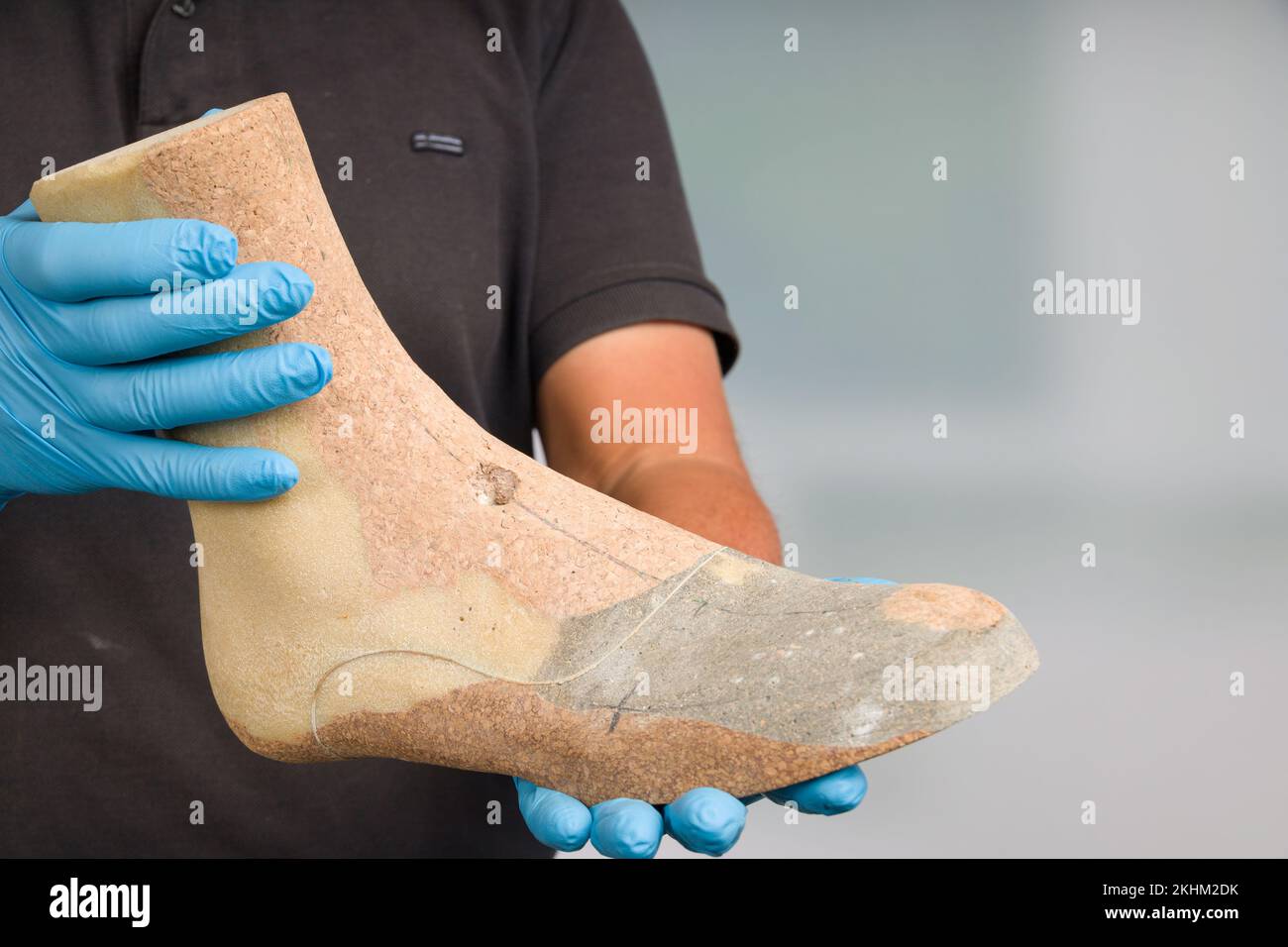 close-up of shoemaker's hands handling a individual crafted wooden last to make inlays or shoes Stock Photo