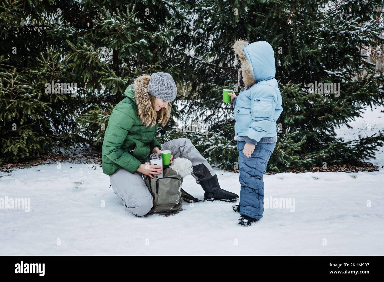 Outdoors winter activities for family. Happy Family, mother, boy kid and dog walking, having fun