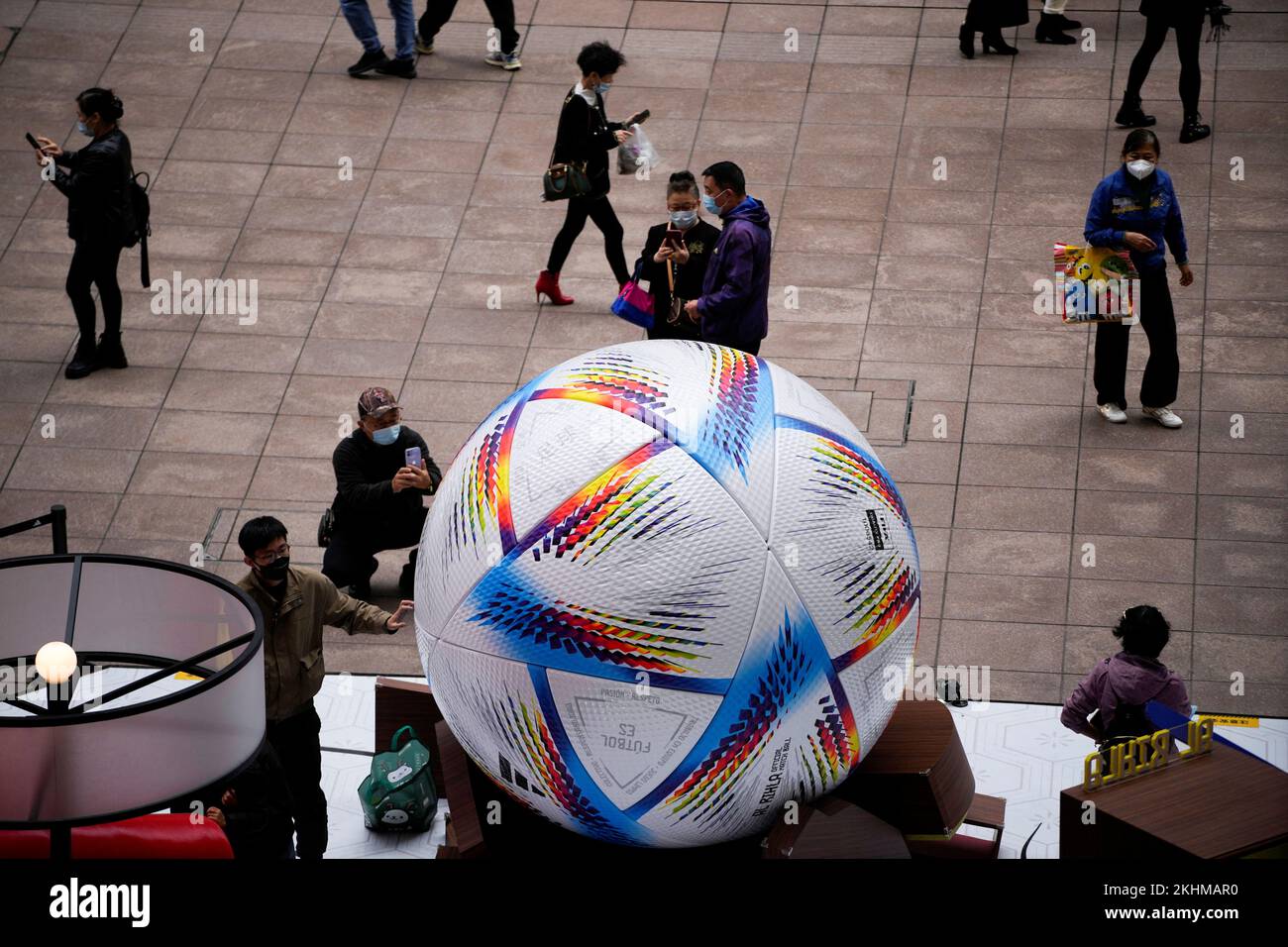 People wearing face masks look at the giant model of FIFA World Cup Qatar 2022 match ball, amid the coronavirus disease (COVID-19) outbreak in Shanghai, China, November 23, 2022. REUTERS/Aly Song Stock Photo