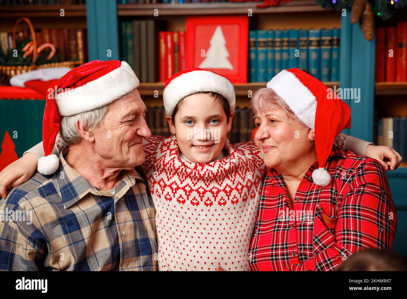 Excited grandchild greeting grandparents visiting on Christmas day. Stock Photo