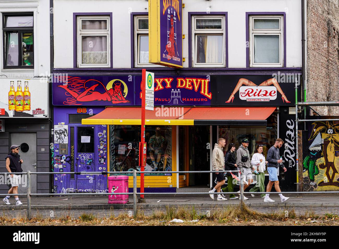 A group of tourists is taking a walk. Ammm. Days across the Reeperbahn and walks past an erotic bar. Stock Photo