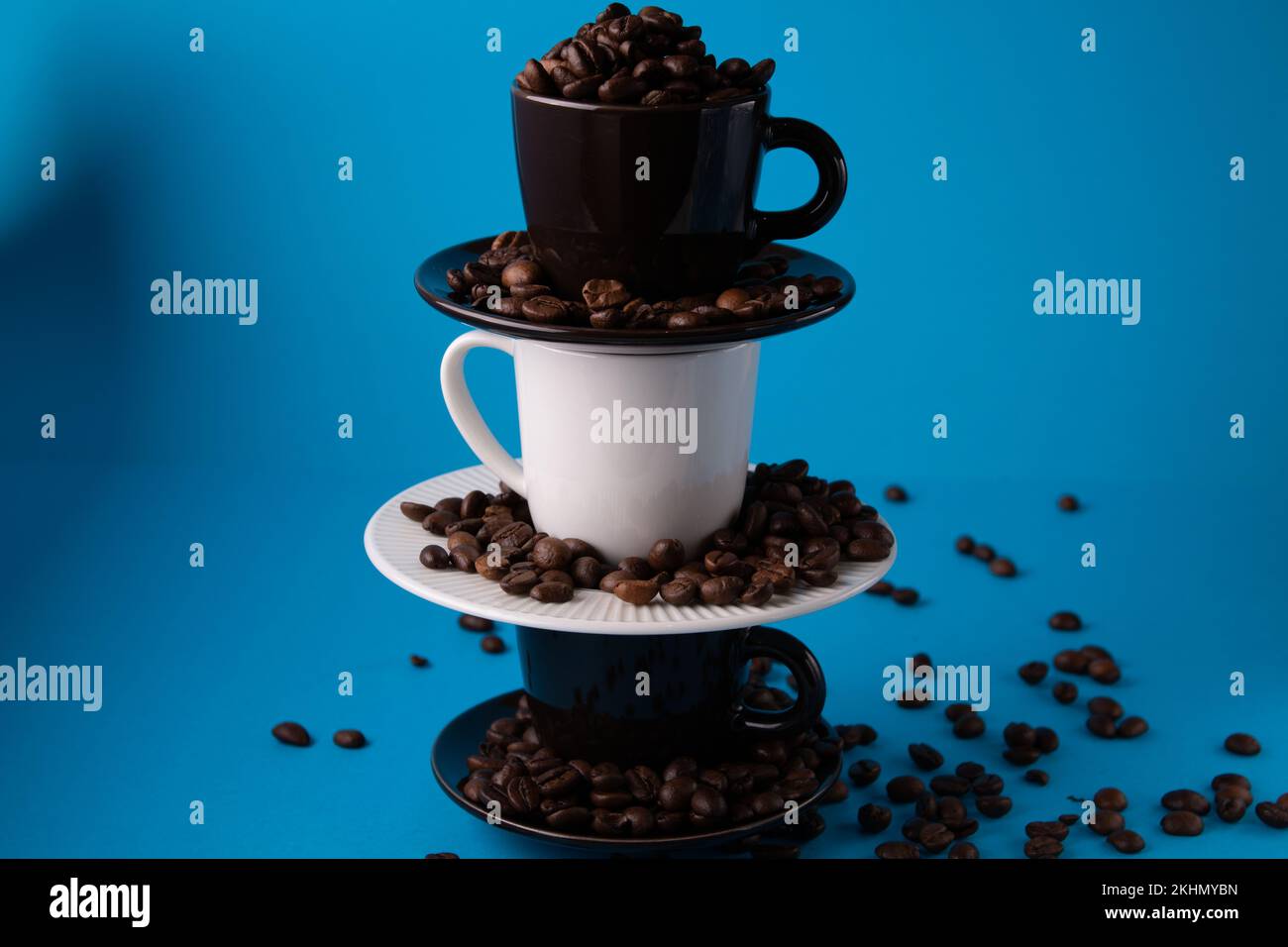 https://c8.alamy.com/comp/2KHMYBN/photo-of-a-cup-with-coffee-beans-on-top-of-a-pyramid-of-cups-2KHMYBN.jpg