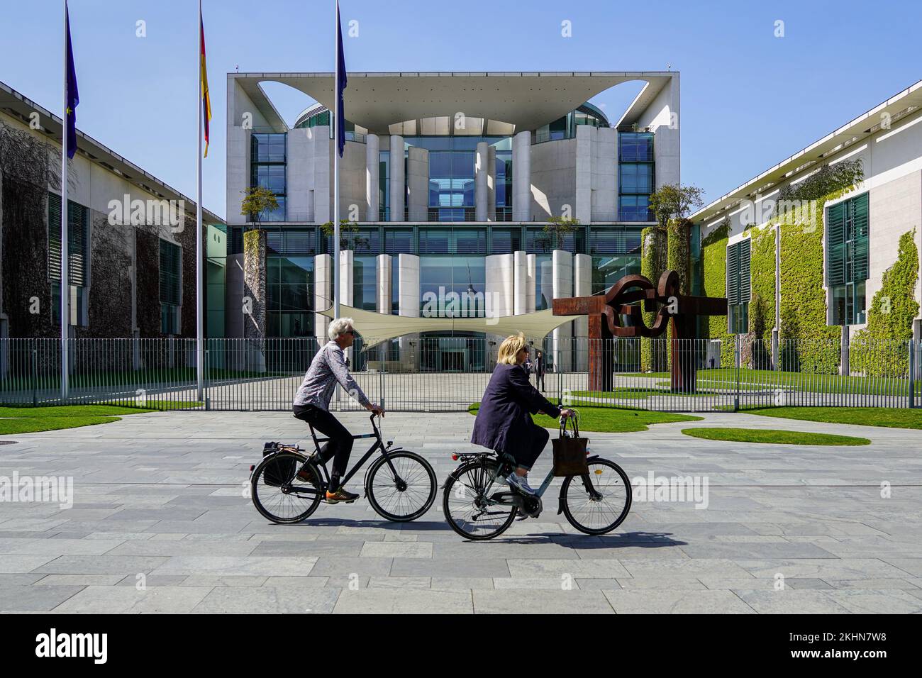 Two cyclists pass the Federal Chancellery in the government district in Berlin. Stock Photo