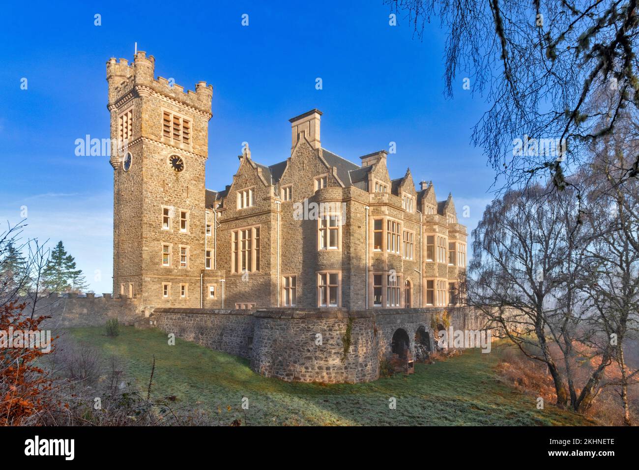 Carbisdale Castle Invershin Scotland blue sky and an early morning mist over the building and garden Stock Photo