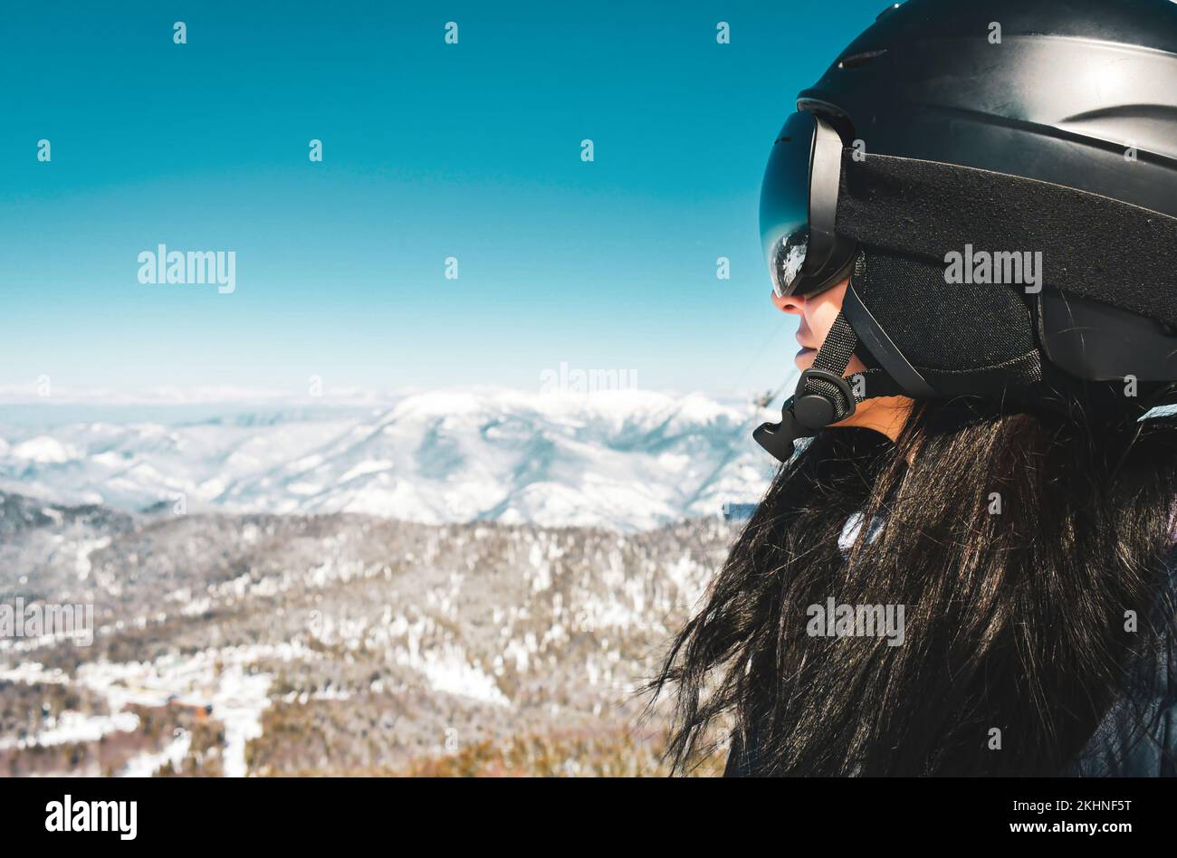 Close up skier snowboarder female person portrait with goggles look out to mountains panorama reflection. Ski holiday in Georgia caucasus mountains Stock Photo