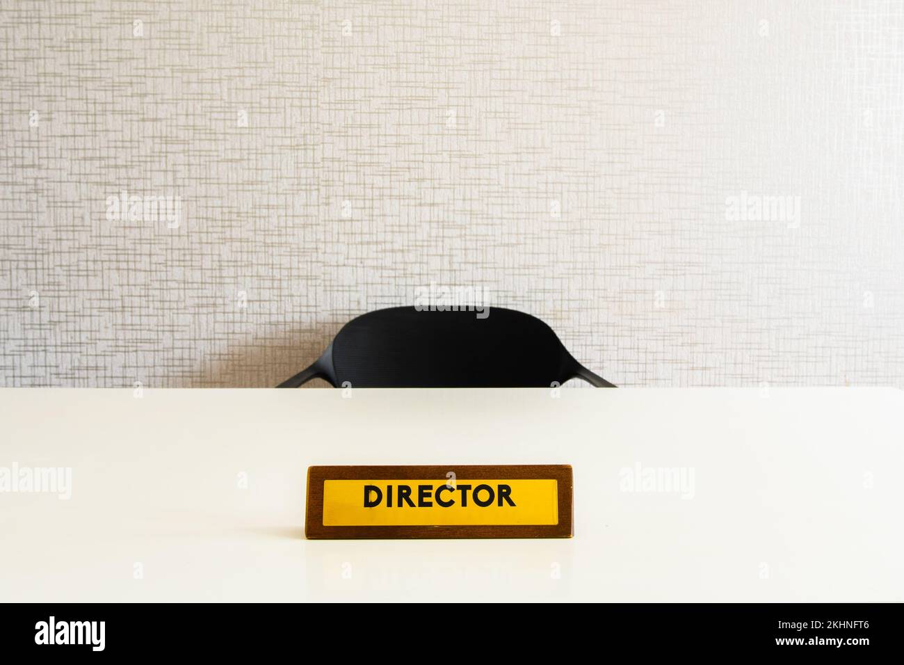 Wooden director office plate on white glossy table with empty chair in room Stock Photo