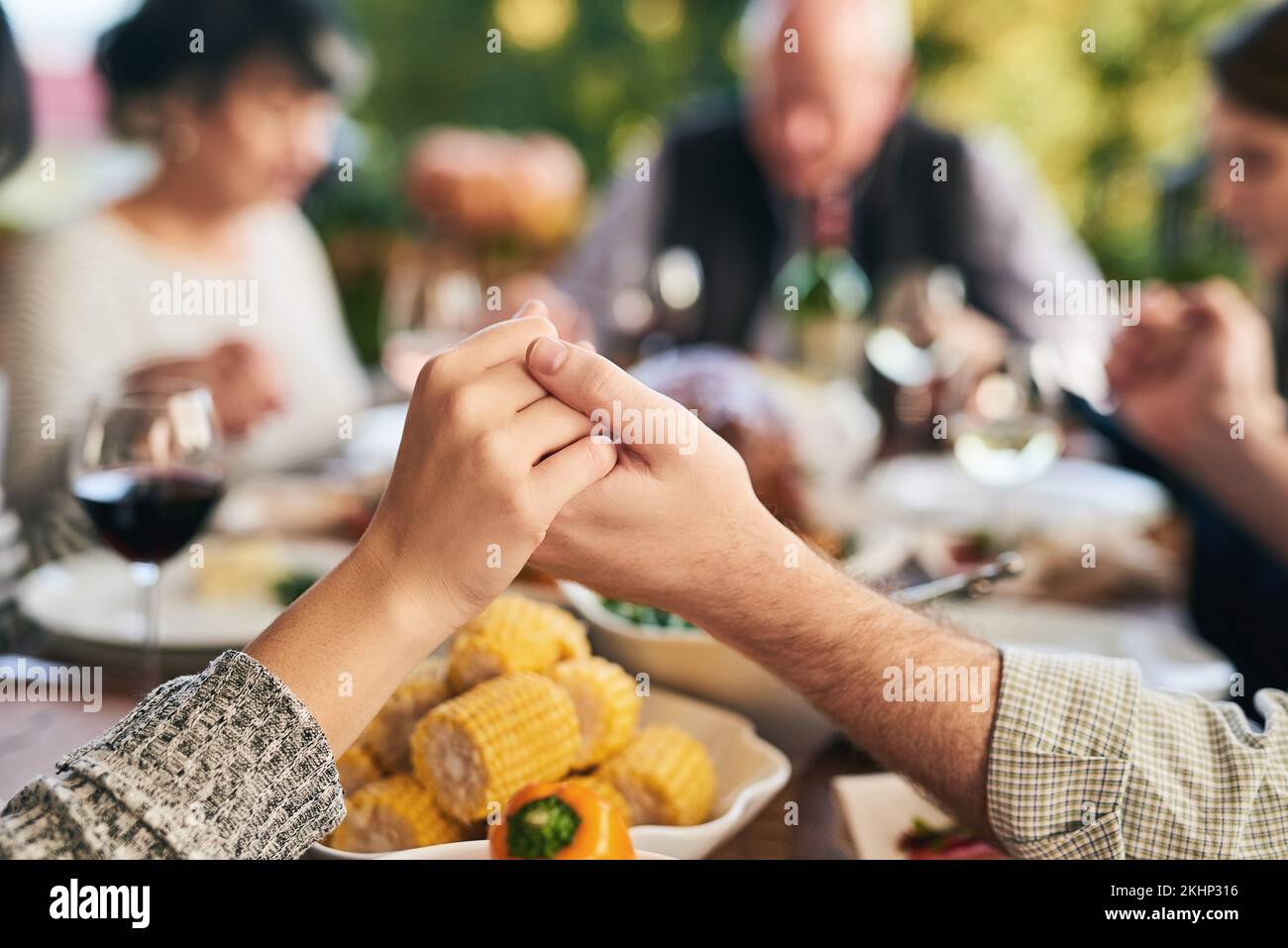 Party, food and family holding hands for prayer before eating chicken