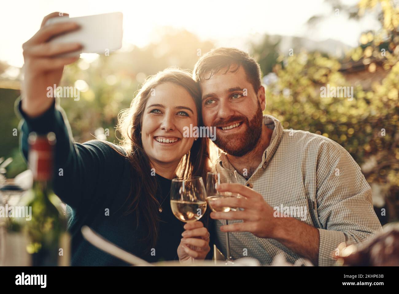 Wine, phone and couple take a selfie with a toast to a happy marriage and share romantic content on social media. Woman smiles taking pictures on a Stock Photo