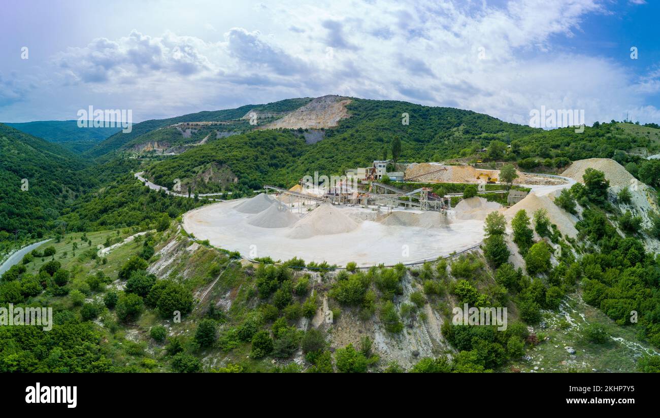 Mining on mountain in valley of Rhodope Mountains with forests and cloudy sky. Panorama, top view Stock Photo