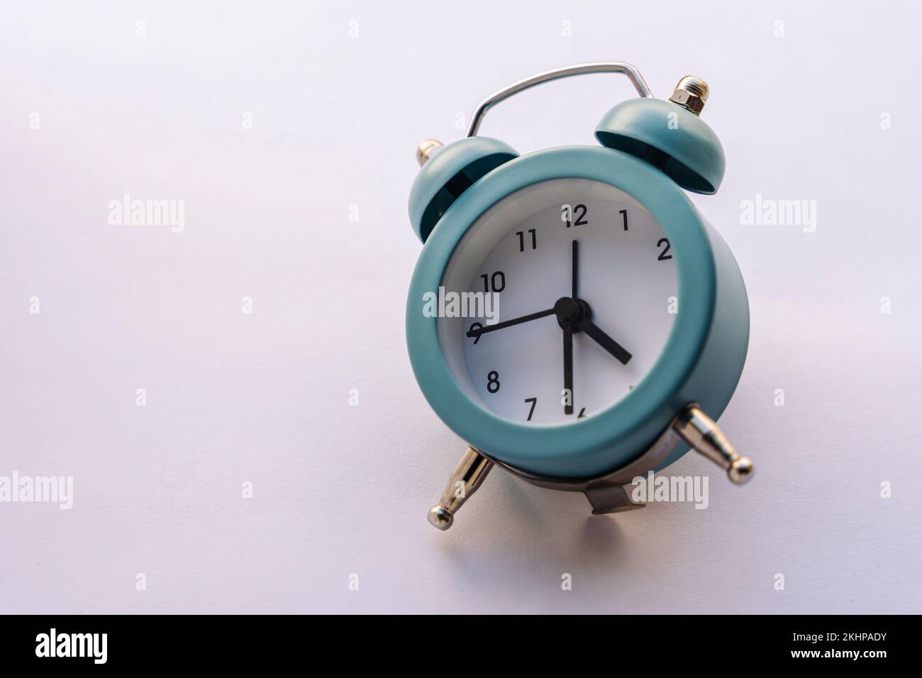 small blue alarm clock in vintage style on a white background Stock ...