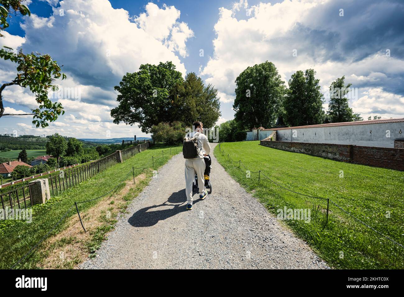 Back of father with baby carriage walking at Chateau Kunstat, Czech Republic Stock Photo