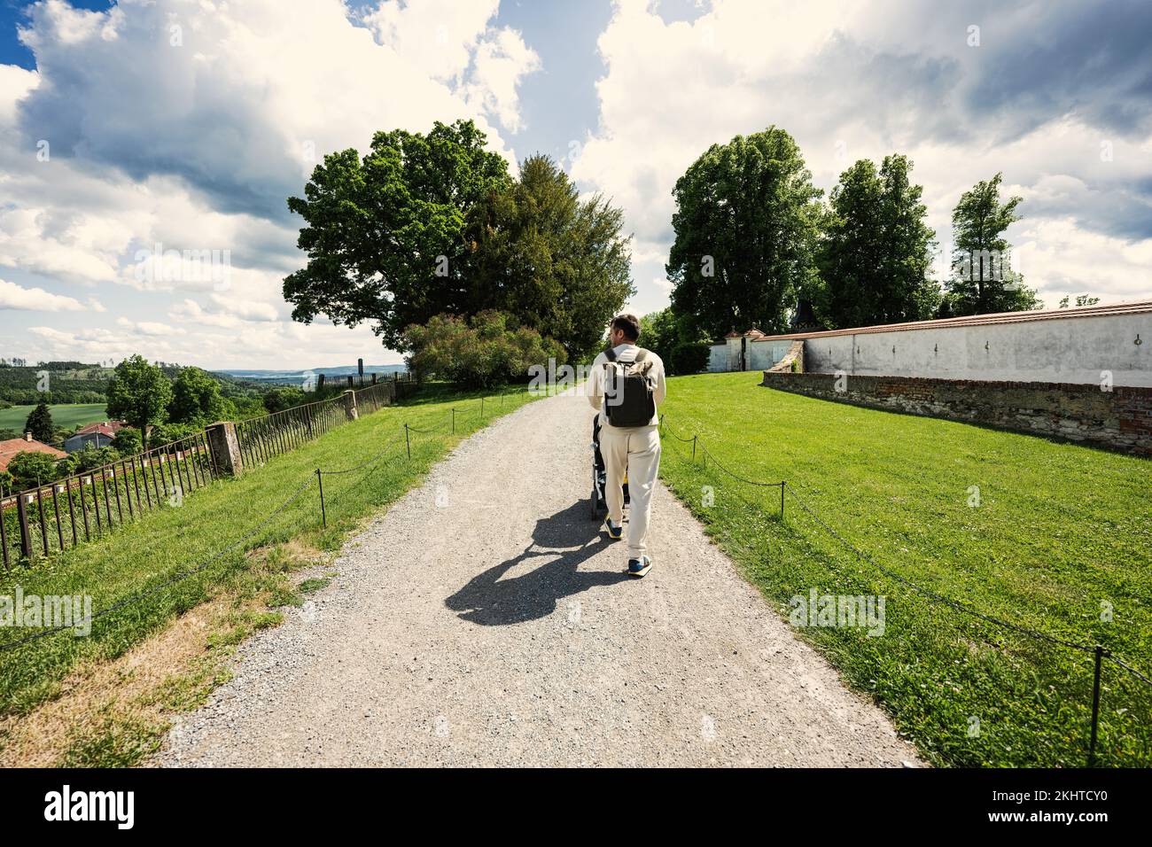 Back of father with baby carriage walking at Chateau Kunstat, Czech Republic Stock Photo