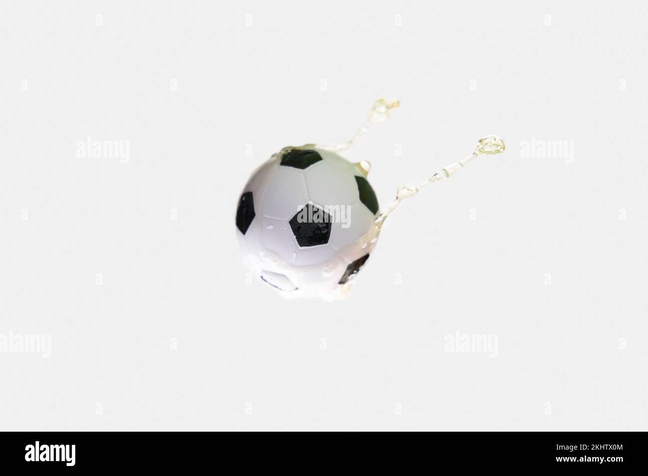 Soccer ball in beer splash on white background. Concept of soccer and