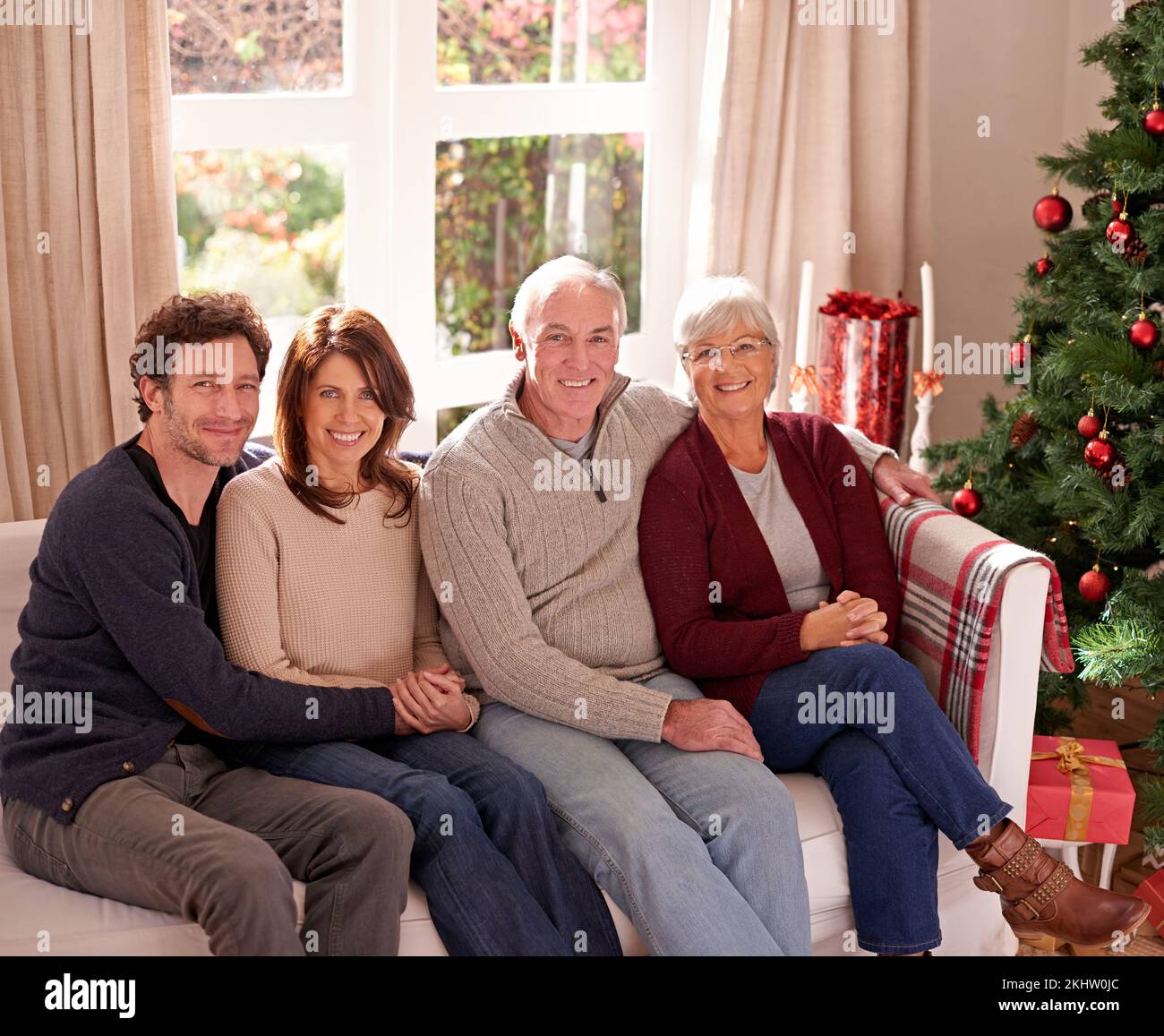 Christmas, family and together on sofa for portrait in living room to celebrate festive holiday. Quality time, relax and happy family relax for Stock Photo