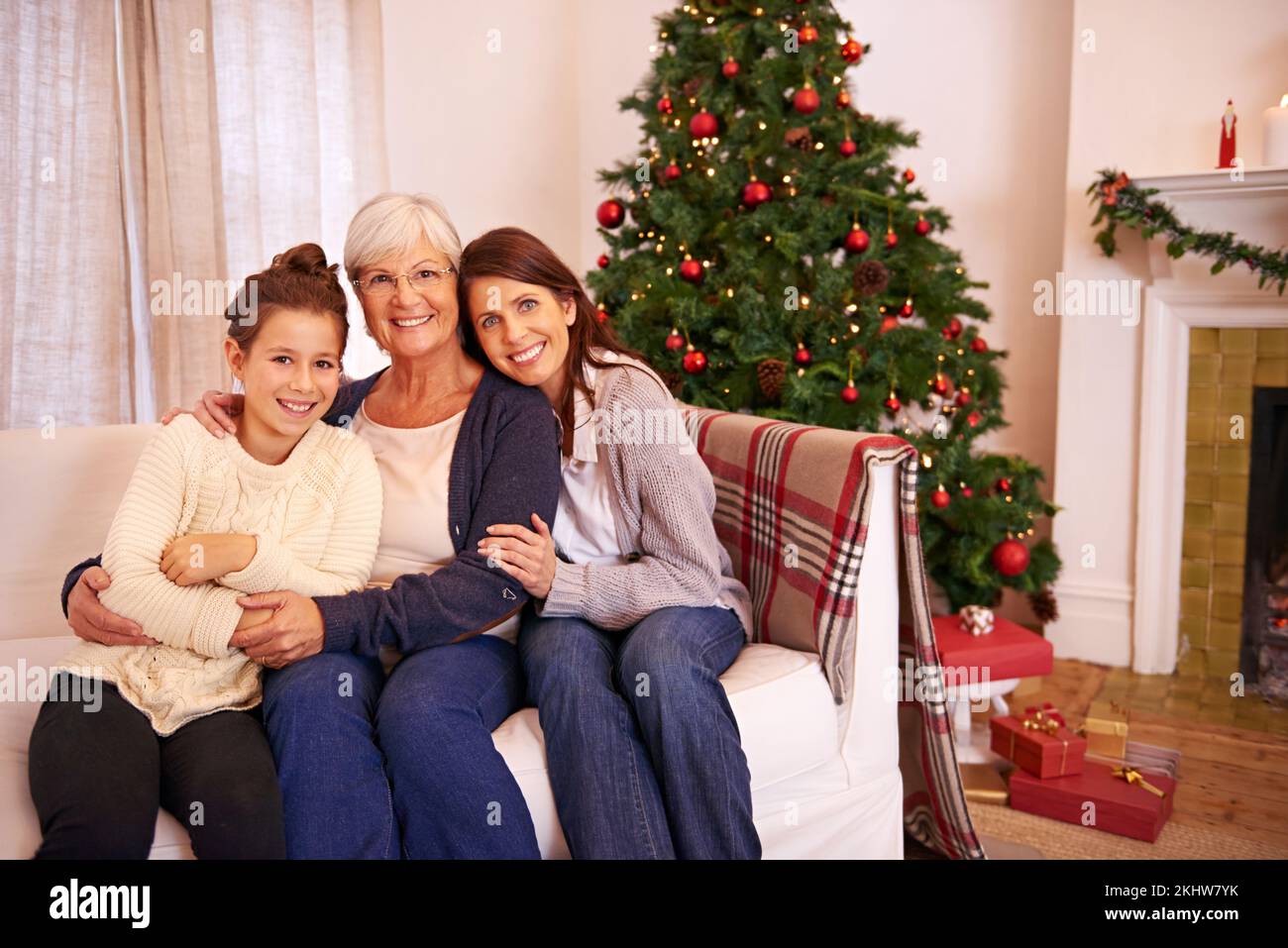 Christmas, portrait and family on sofa by mother, girl and grandma in celebration of bonding tradition in their home. Happy family, generations and Stock Photo