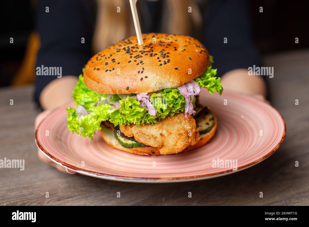 Large tasty, delicious hamburger with skewer on plate in restaurant