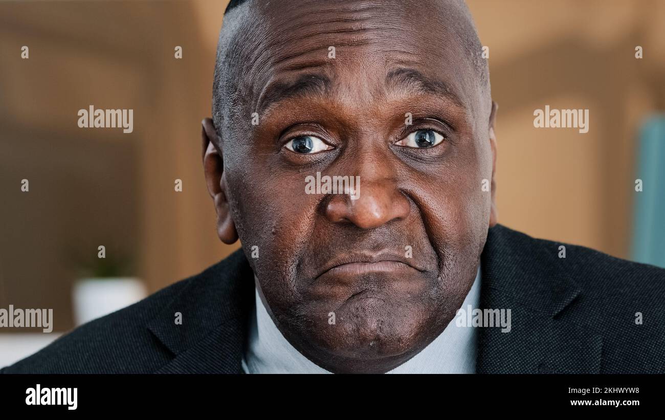 Extreme closeup old wrinkled emotional businessman African American