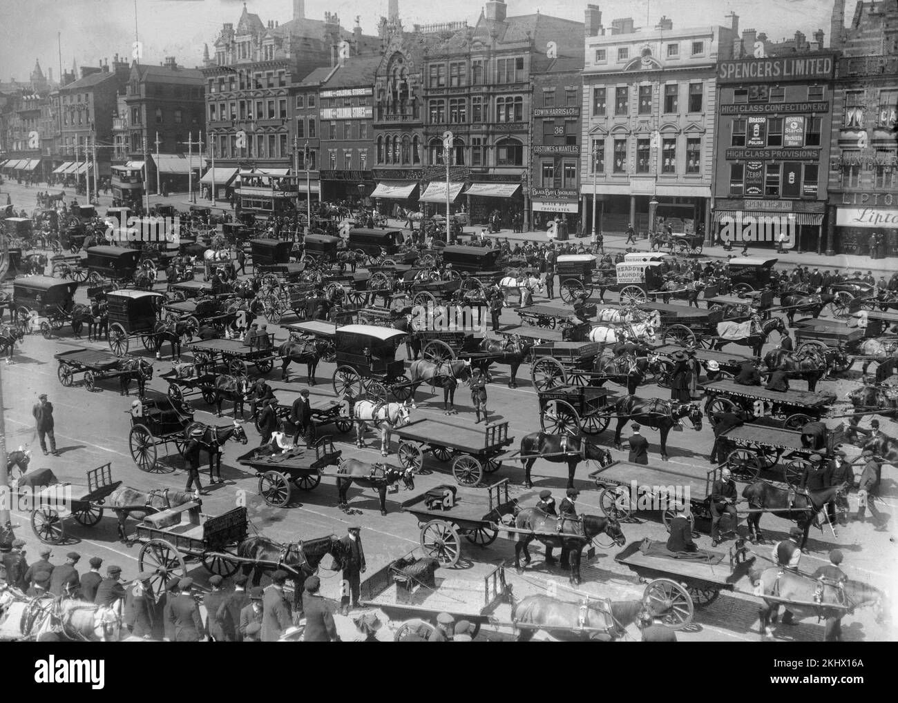 A late Victorian black and white photograph showing the centre of Nottingham in England, with many horse drawn carriages and carts on the streets. The names of many shops are visible. Stock Photo