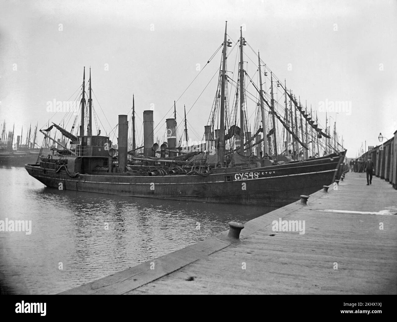 A late Victorian black and white photograph showing a steam trawler, number GY548 and named Cetus, in dock in an English town. Stock Photo