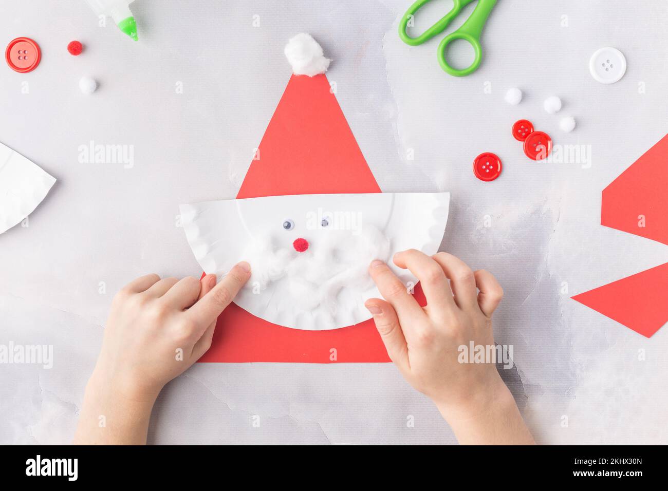 The child makes a greeting card Christmas paper collage. Made with his own hands. Children's art project craft for kids. Craft for children. Top view Stock Photo