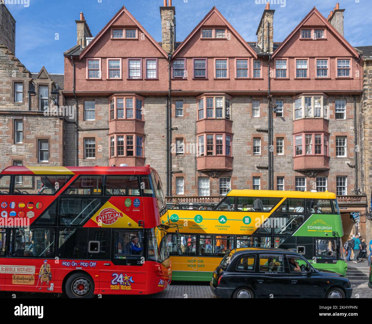 Colourful tour buses in front of 453-463 Lawnmarket in Edinburgh's historic Royal Mile Stock Photo