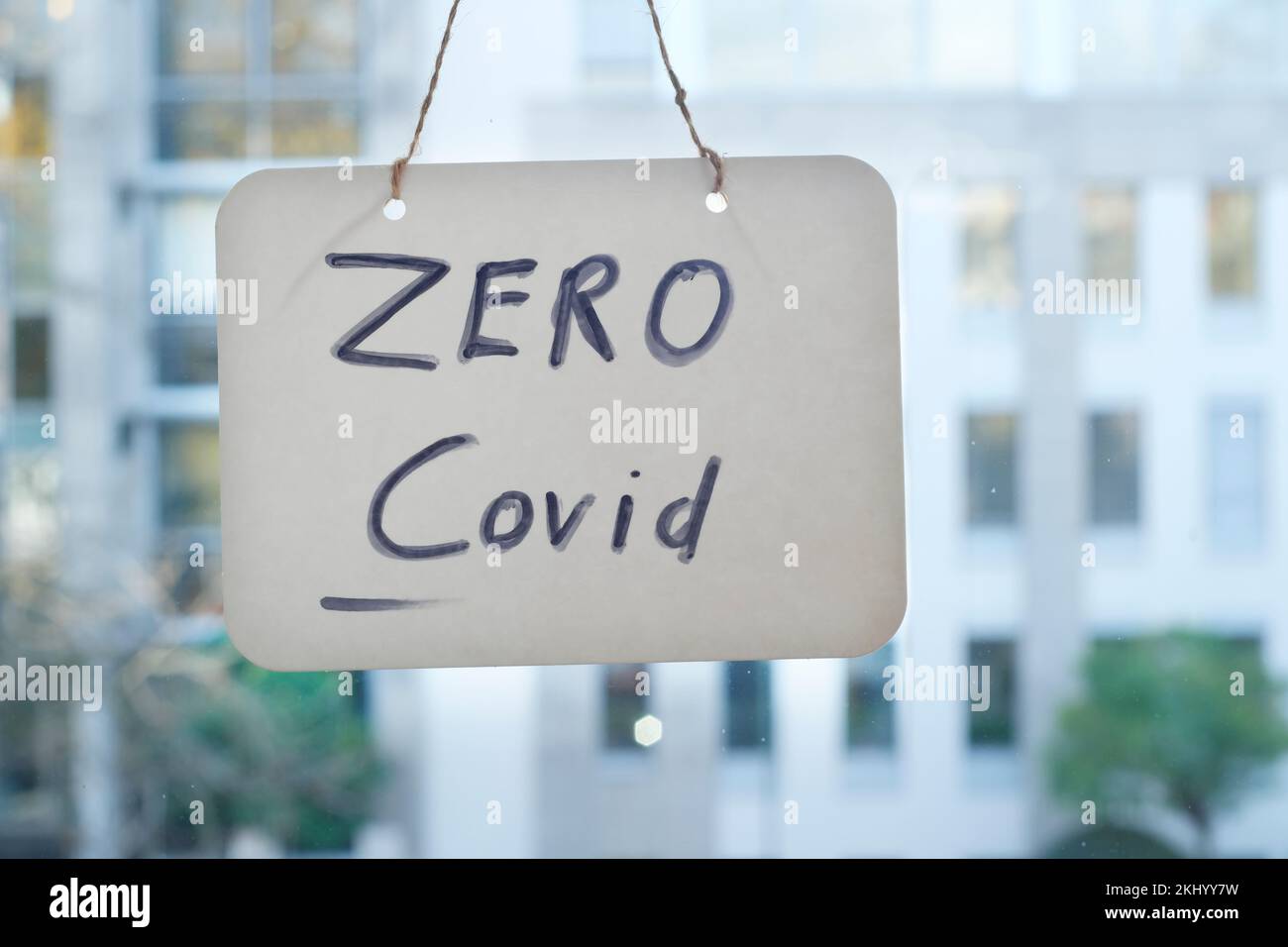 Zero covid sign on window, office buildings in the back. Stock Photo