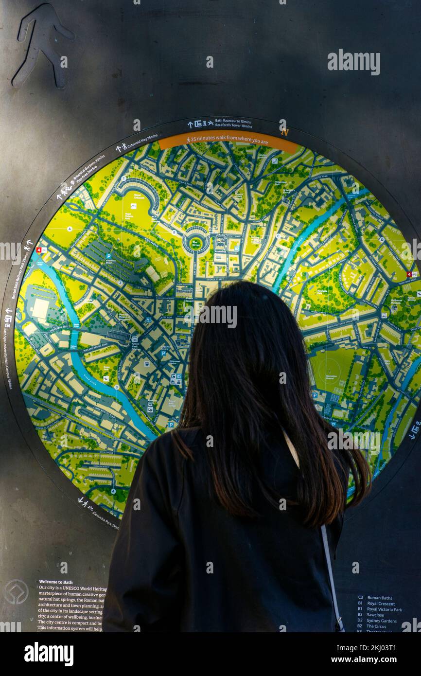 A tourist looks at a street map by Pulteney Bridge in Bath Spa, Somerset, England, UK Stock Photo