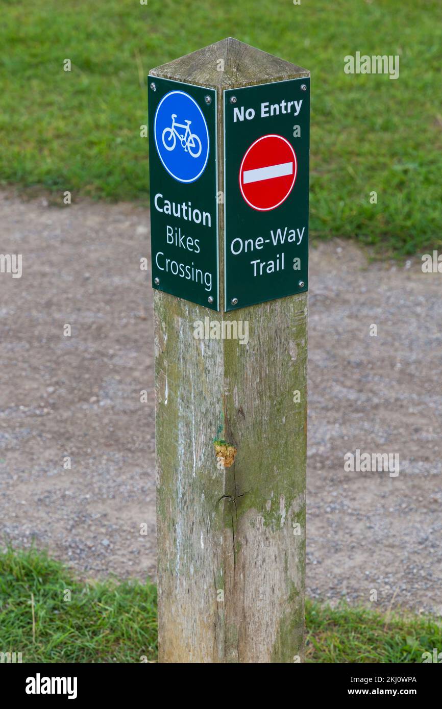 Caution bikes crossing no entry one-way trail post at Campbell Park, Milton Keynes, Buckinghamshire, UK in September Stock Photo
