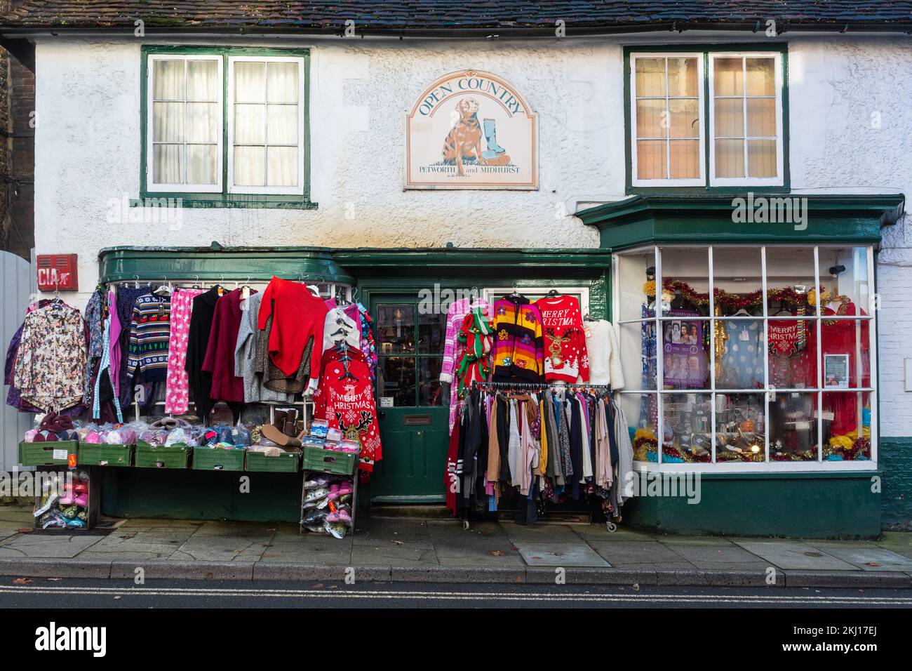 Christmas jumpers and other sweaters displayed outside an independent shop in Midhurst, West Sussex, England, UK Stock Photo