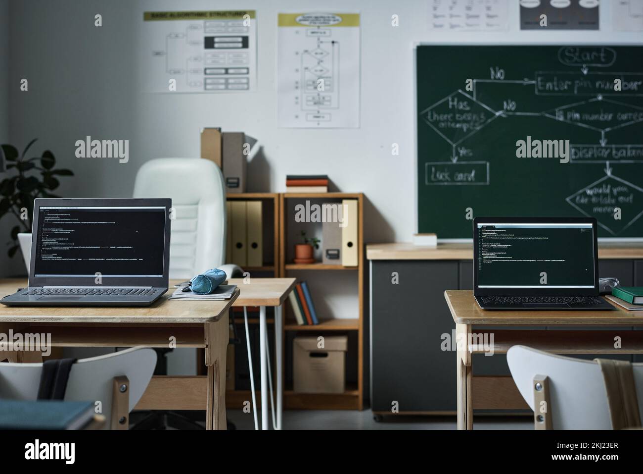 Horizontal image of modern empty class with computers with coding on monitors for IT lesson Stock Photo