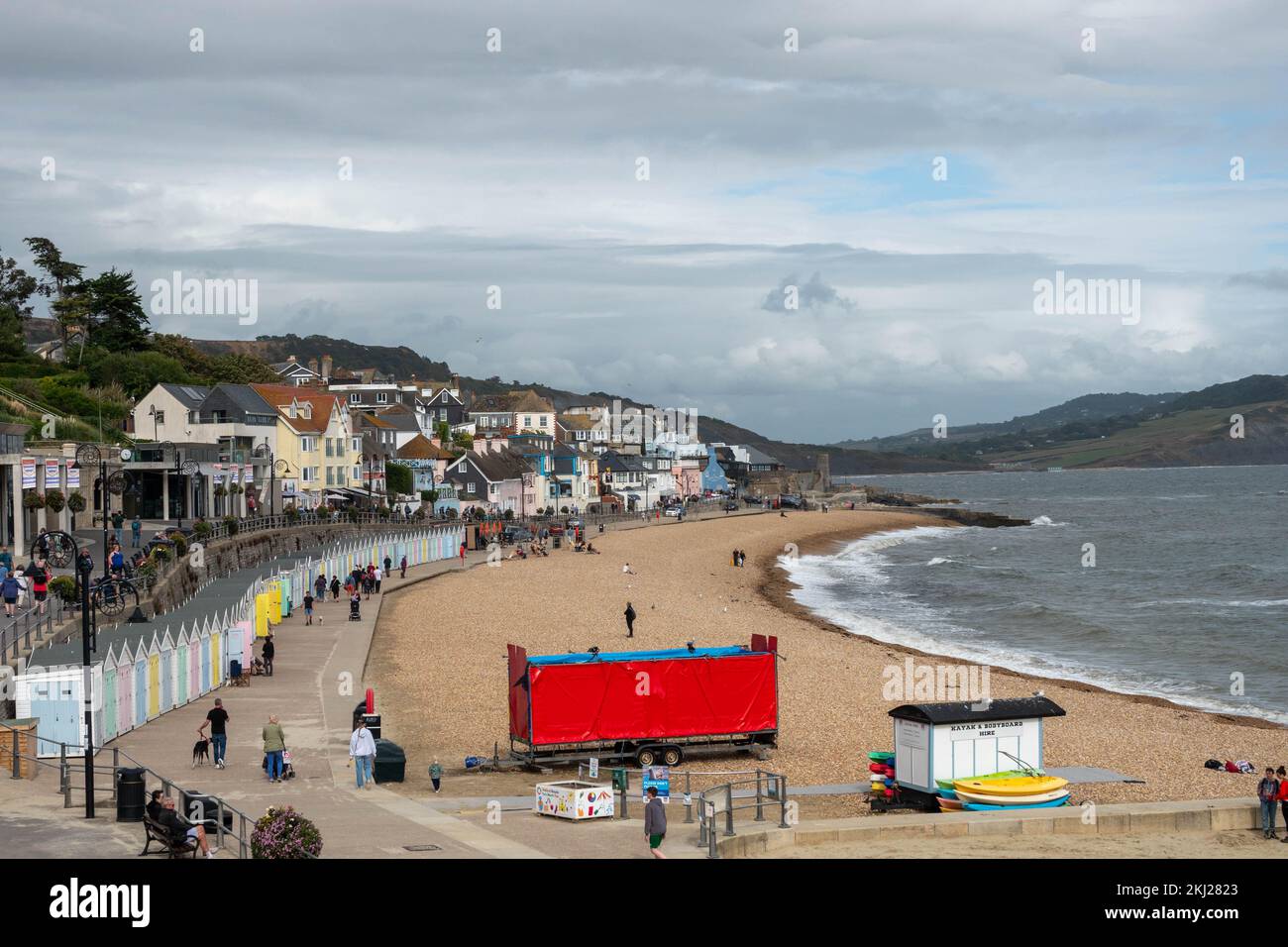view of beach huts beach and traditional cottages in the historic seaside town of Lyme Regis also known as The Pearl of Dorset Stock Photo
