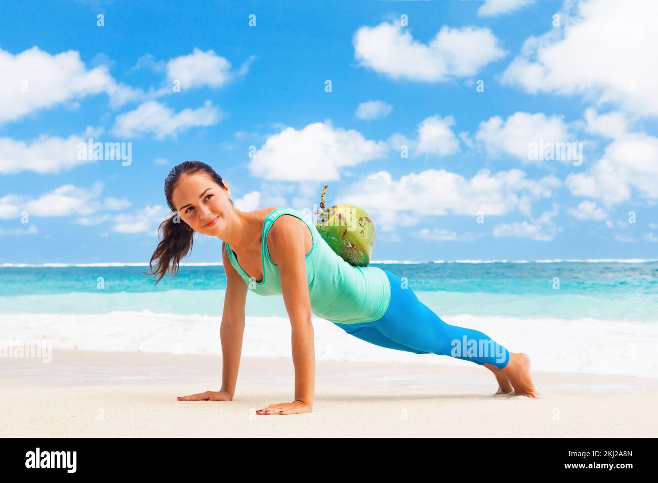 At sea beach active woman doing fitness exercises plank, push up with