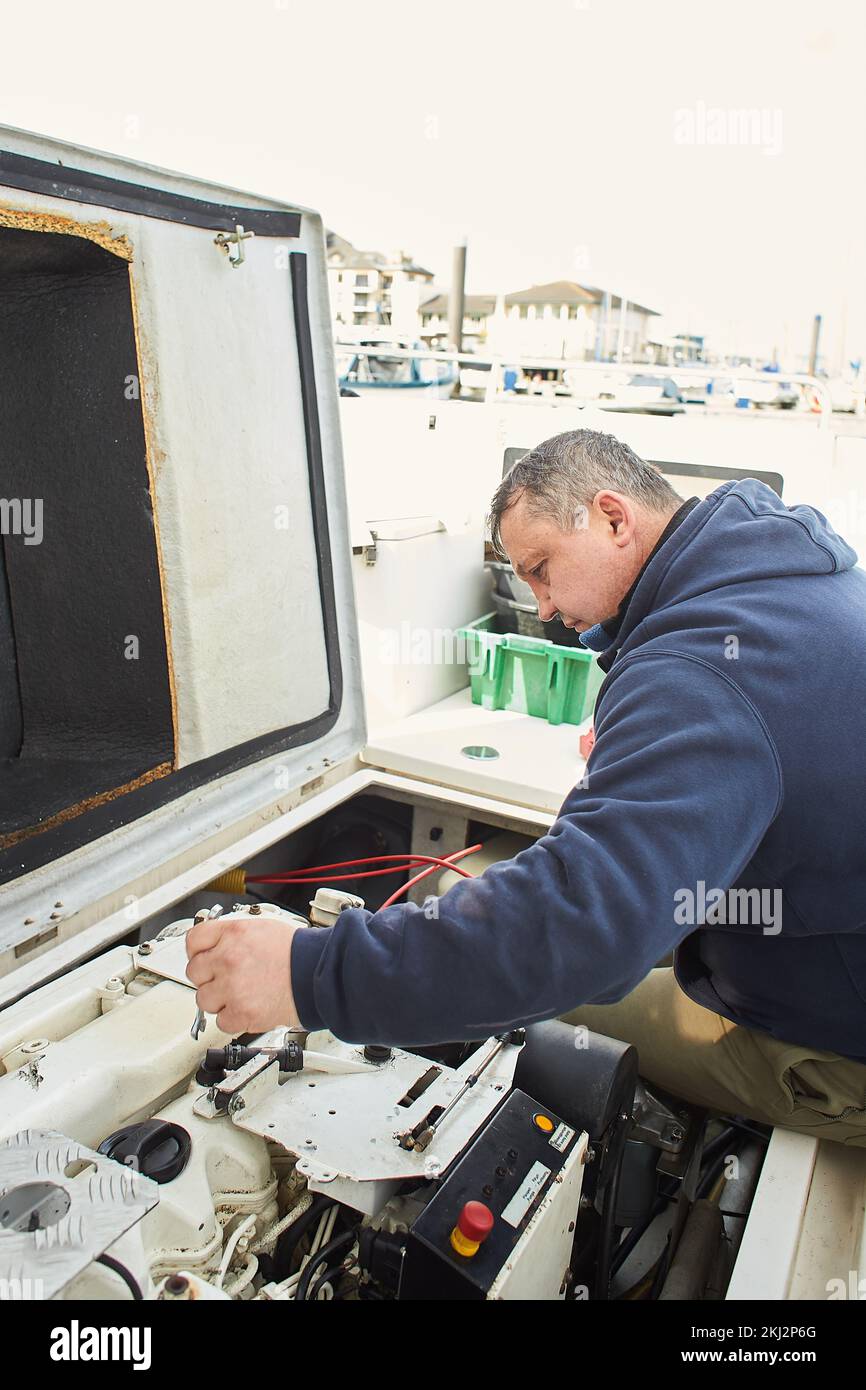 Boat mechanic repairing a ship engine Stock Photo Alamy