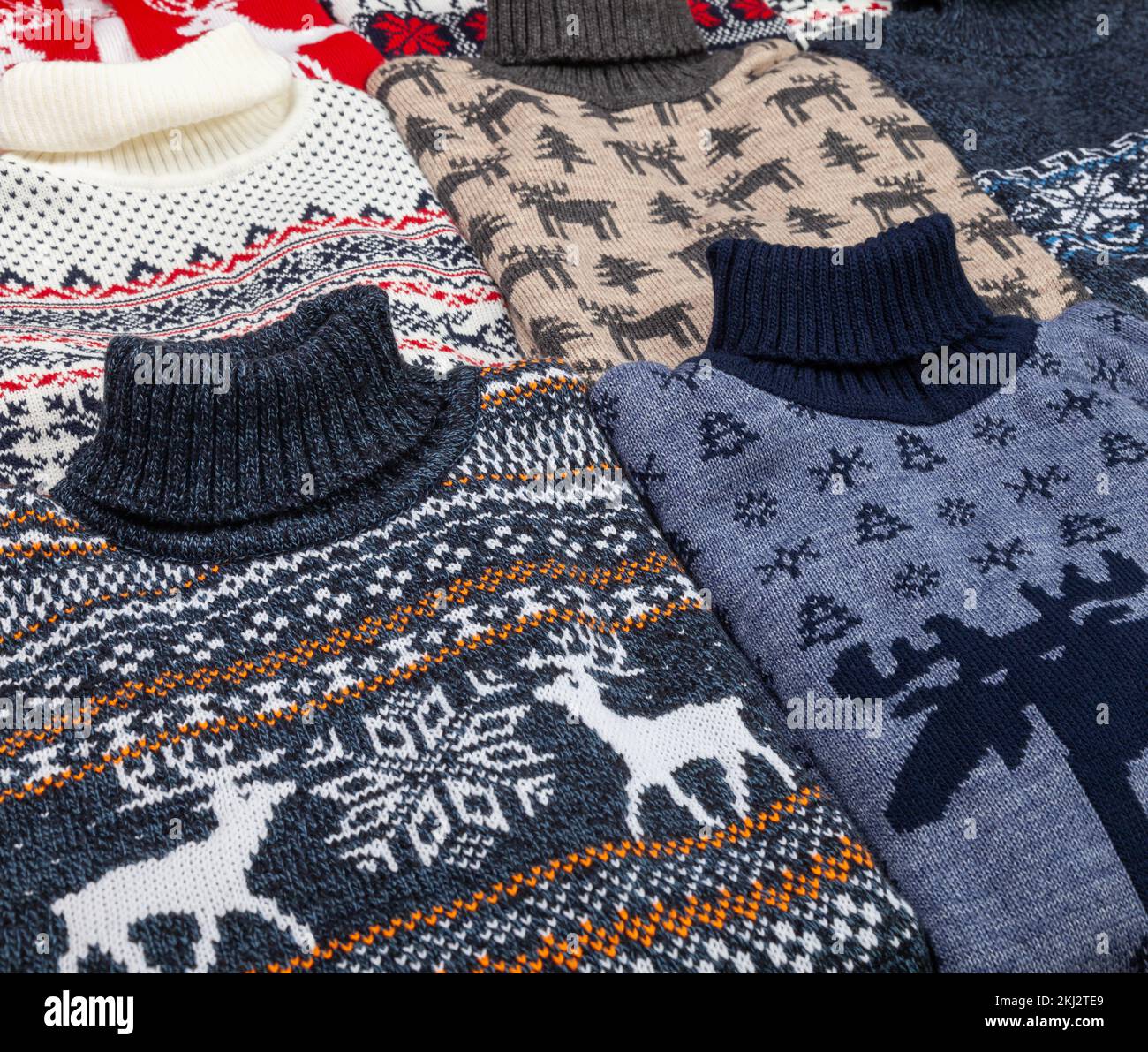 Various knitted Christmas pullovers with nordic ornament (aka Ugly Sweater) laid folded Stock Photo
