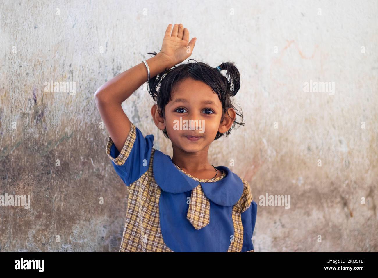 School girl Raising Hand in classroom Stock Photo