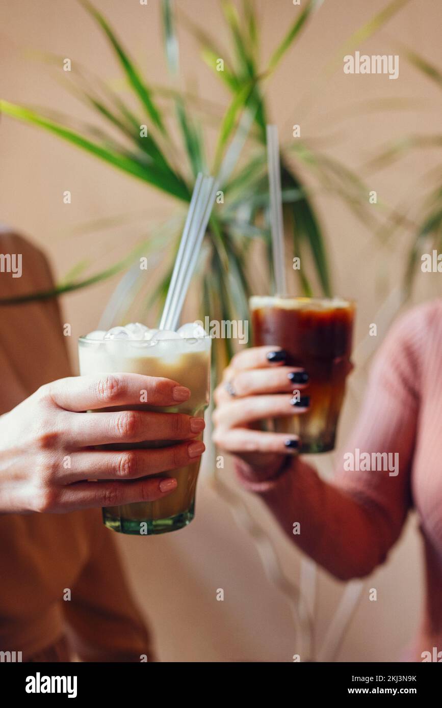 Happy young female friends having coffee break while relaxing at indoor